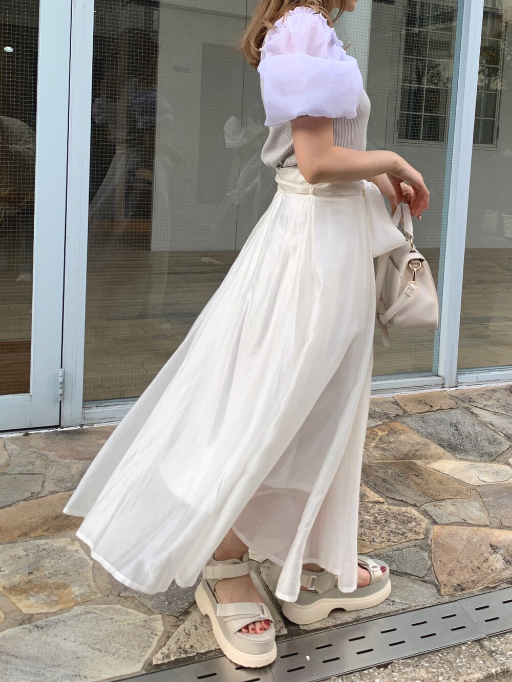 グレー系のTシャツ/カットソー、ホワイト系のスカート、ホワイト系のサンダルを着用したレディースの春コーディネートの2枚目の写真