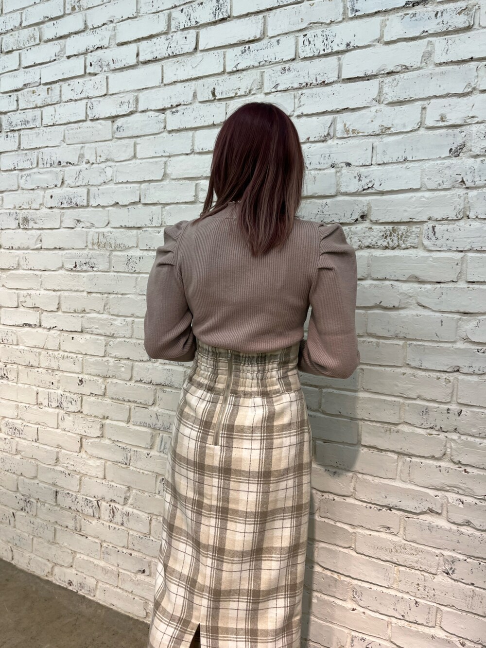 ブラウン系のニット/セーター、ブラウン系のスカート、ブラウン系のショルダーバッグを着用したレディースの秋コーディネートの3枚目の写真