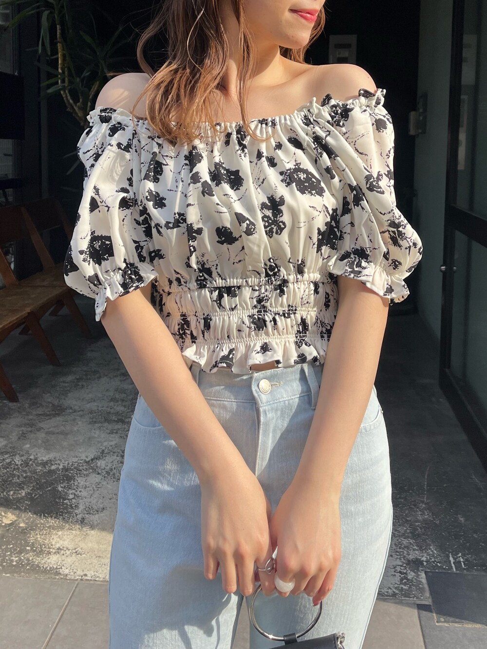 ブラック系のシャツ/ブラウス、ホワイト系のサンダル、ブルー系のデニムパンツを着用したレディースの春コーディネートの2枚目の写真