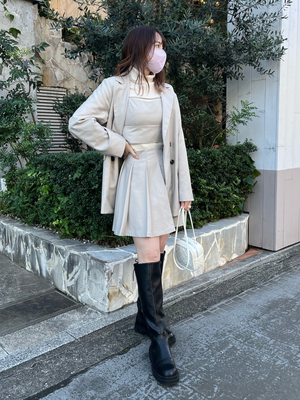 ベージュ系のキャミソール、ベージュ系のスカート、ブラック系のニット/セーターを着用したレディースの冬コーディネートの2枚目の写真