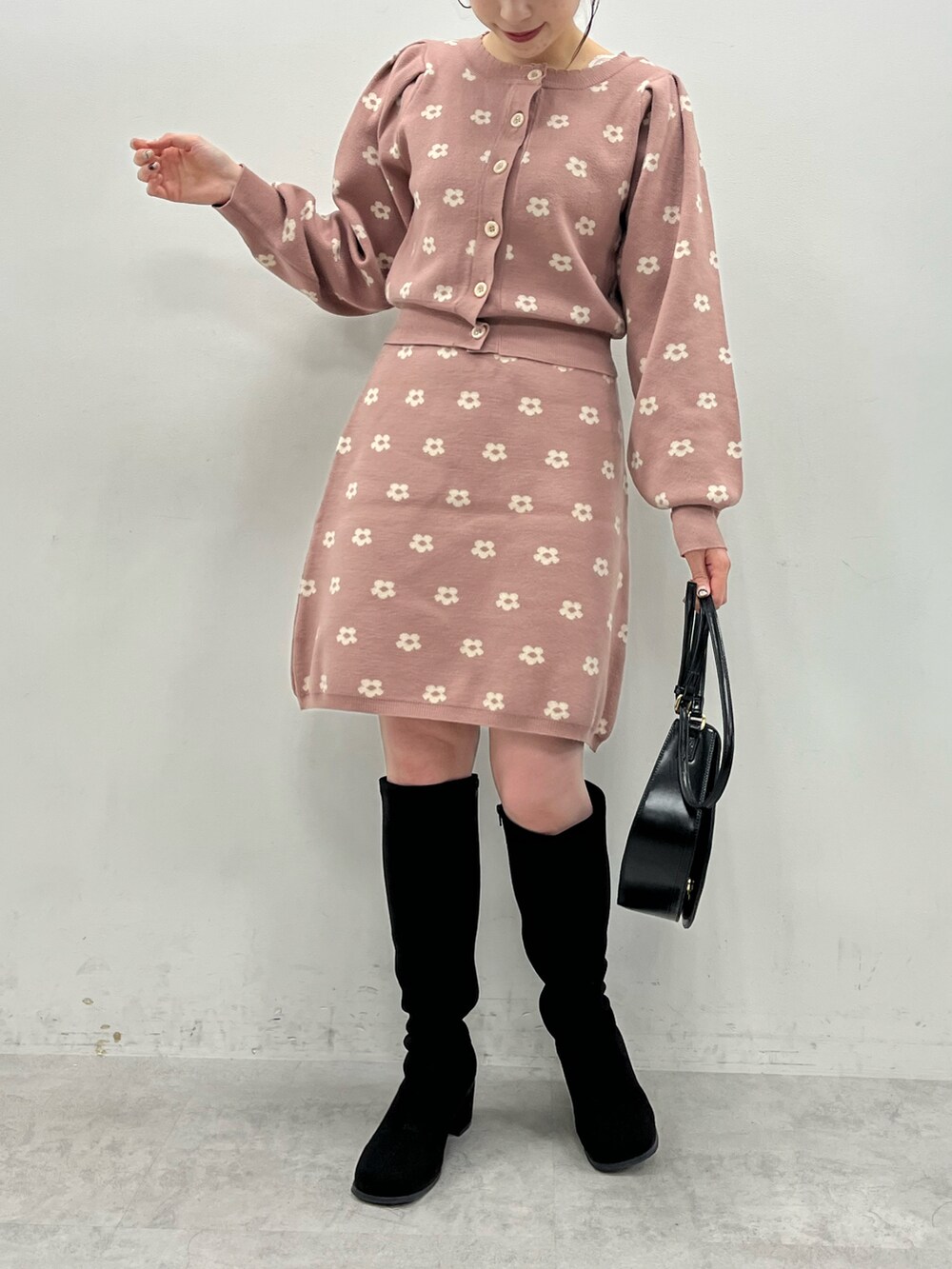 ピンク系のワンピース、ブラック系のショルダーバッグ、ブラック系のブーツを着用したレディースの秋コーディネートの2枚目の写真