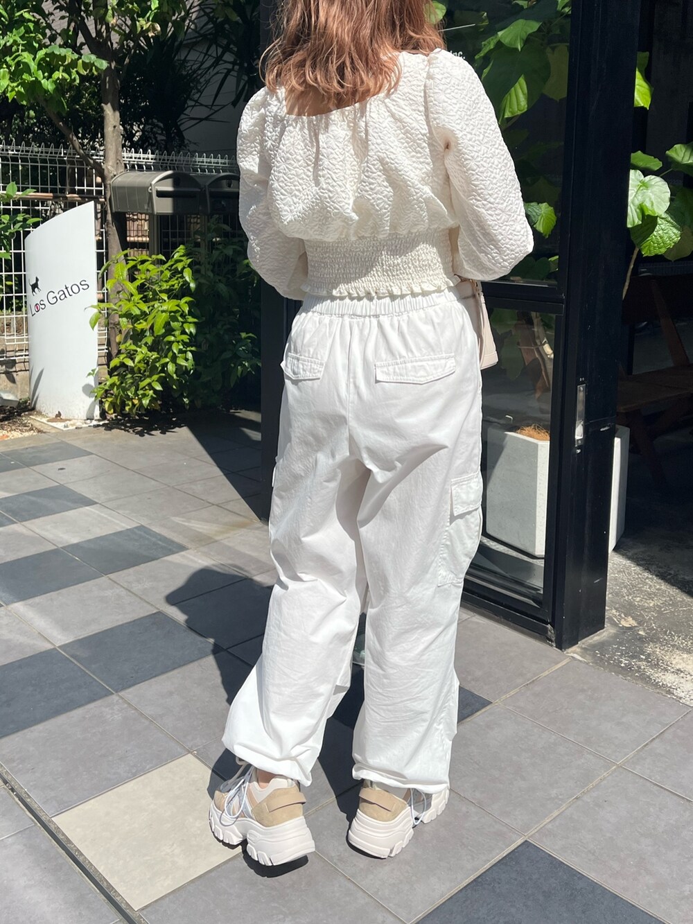 ホワイト系のシャツ/ブラウス、ホワイト系のカーゴパンツ、ベージュ系のスニーカーを着用したレディースの夏コーディネートの2枚目の写真