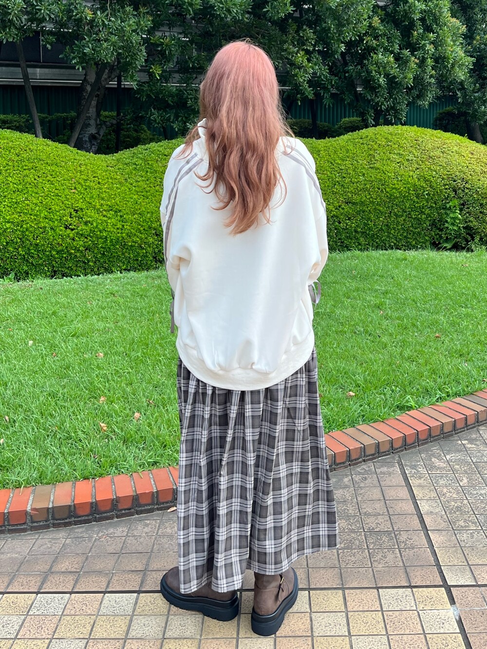 ブラウン系のワンピース、ホワイト系のジャージ、ブラック系のショルダーバッグを着用したレディースの夏コーディネートの3枚目の写真