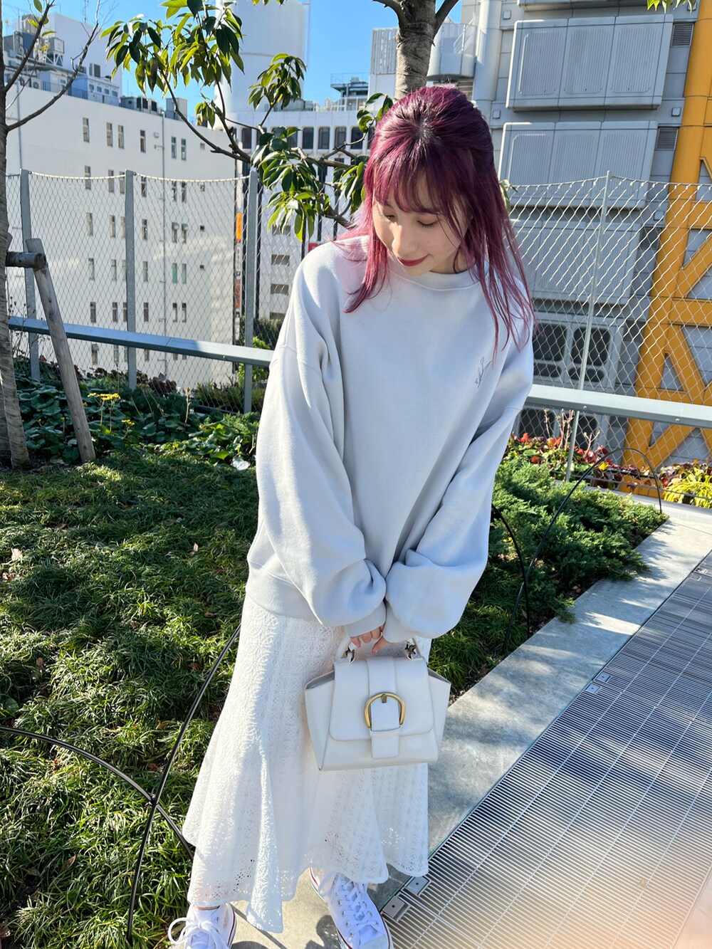 グレー系のスウェット、ホワイト系のデニムジャケット、ホワイト系のスカートを着用したレディースの冬コーディネートの3枚目の写真