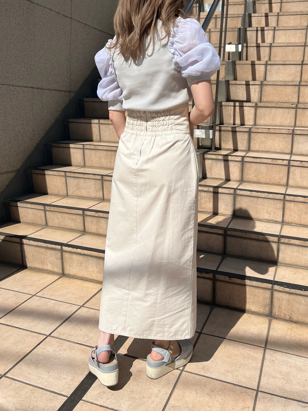 グレー系のTシャツ/カットソー、ホワイト系のスカート、ホワイト系のショルダーバッグを着用したレディースの春コーディネートの2枚目の写真