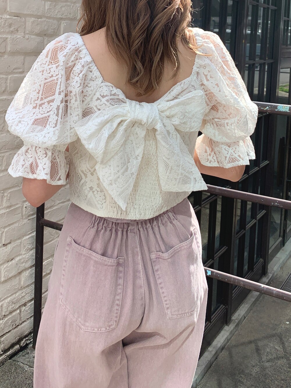 ホワイト系のシャツ/ブラウス、パープル系のデニムパンツ、シルバー系のショルダーバッグを着用したレディースの春コーディネートの3枚目の写真