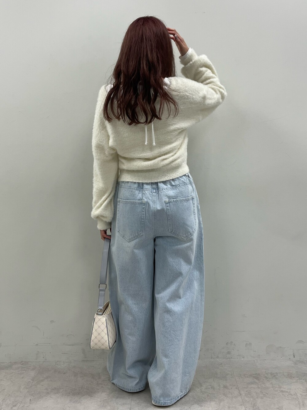 ホワイト系のカーディガン/ボレロ、ブルー系のデニムパンツを着用したレディースの秋コーディネートの3枚目の写真