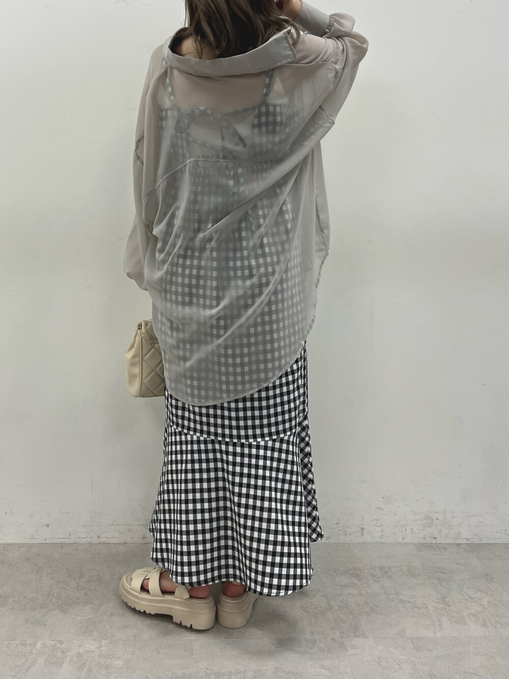 ホワイト系のショルダーバッグ、グレー系のシャツ/ブラウス、ホワイト系のワンピースを着用したレディースの春コーディネートの2枚目の写真