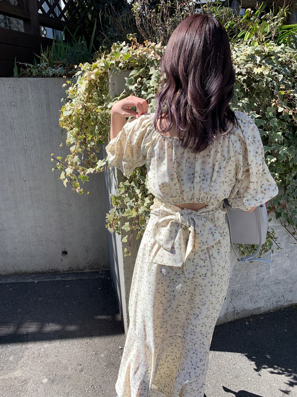 イエロー系のシャツ/ブラウス、イエロー系のスカート、グレー系のショルダーバッグを着用したレディースの春コーディネートの2枚目の写真