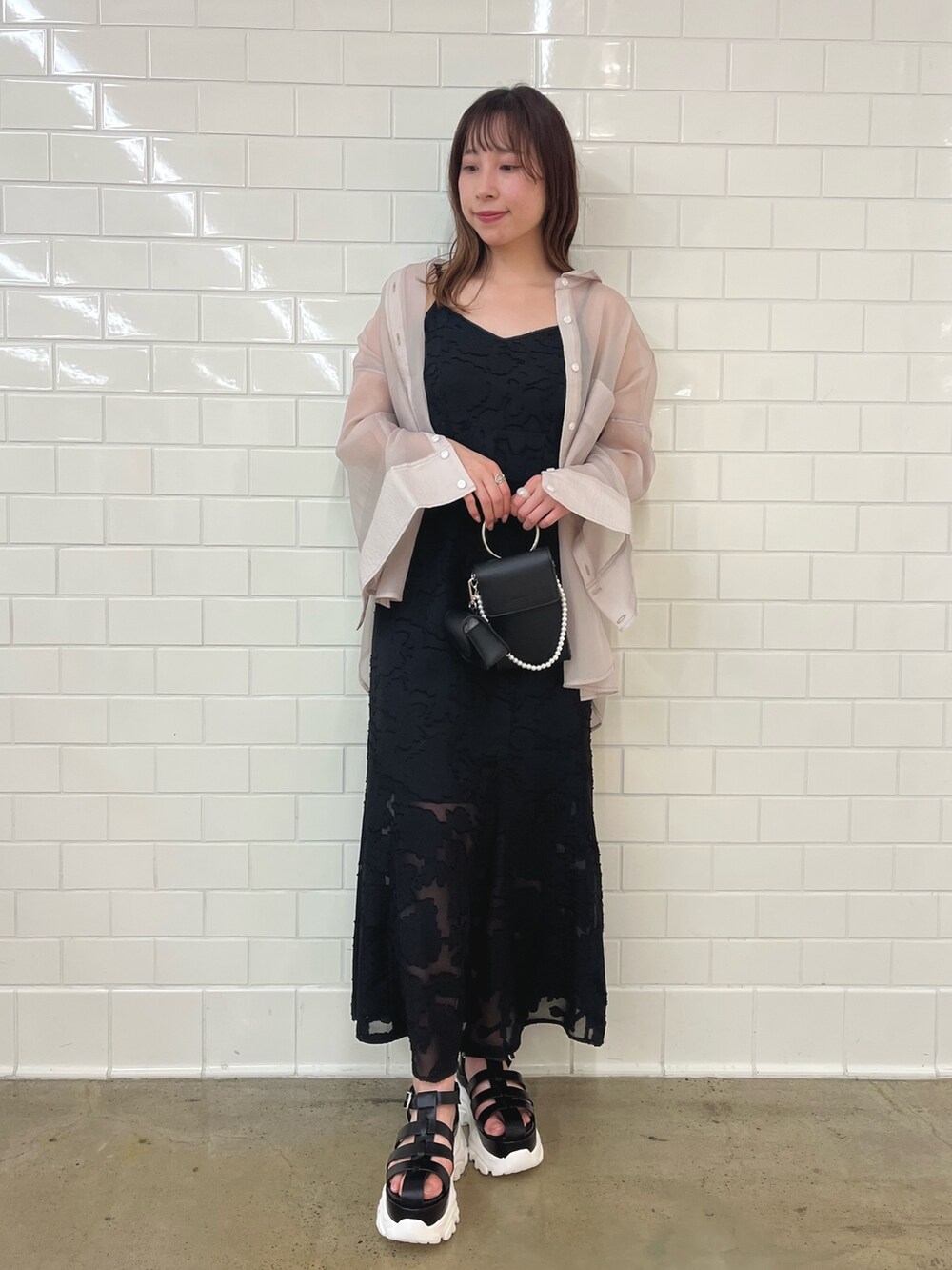 ブラック系のワンピース、ベージュ系のシャツ/ブラウス、ブラック系のショルダーバッグを着用したレディースの冬コーディネートの2枚目の写真