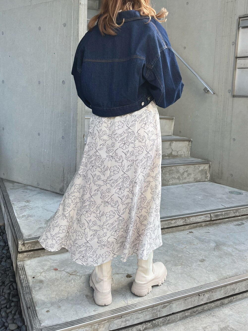 ブルー系のデニムジャケット、ホワイト系のワンピース、グレー系のショルダーバッグを着用したレディースの冬コーディネートの2枚目の写真