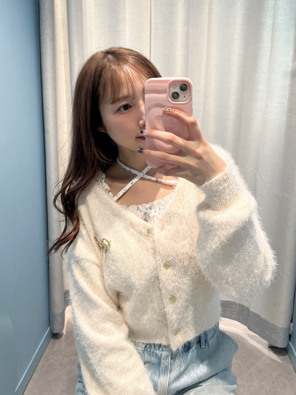 ピンク系のカーディガン/ボレロ、ブルー系のデニムパンツを着用したレディースの冬コーディネートの2枚目の写真