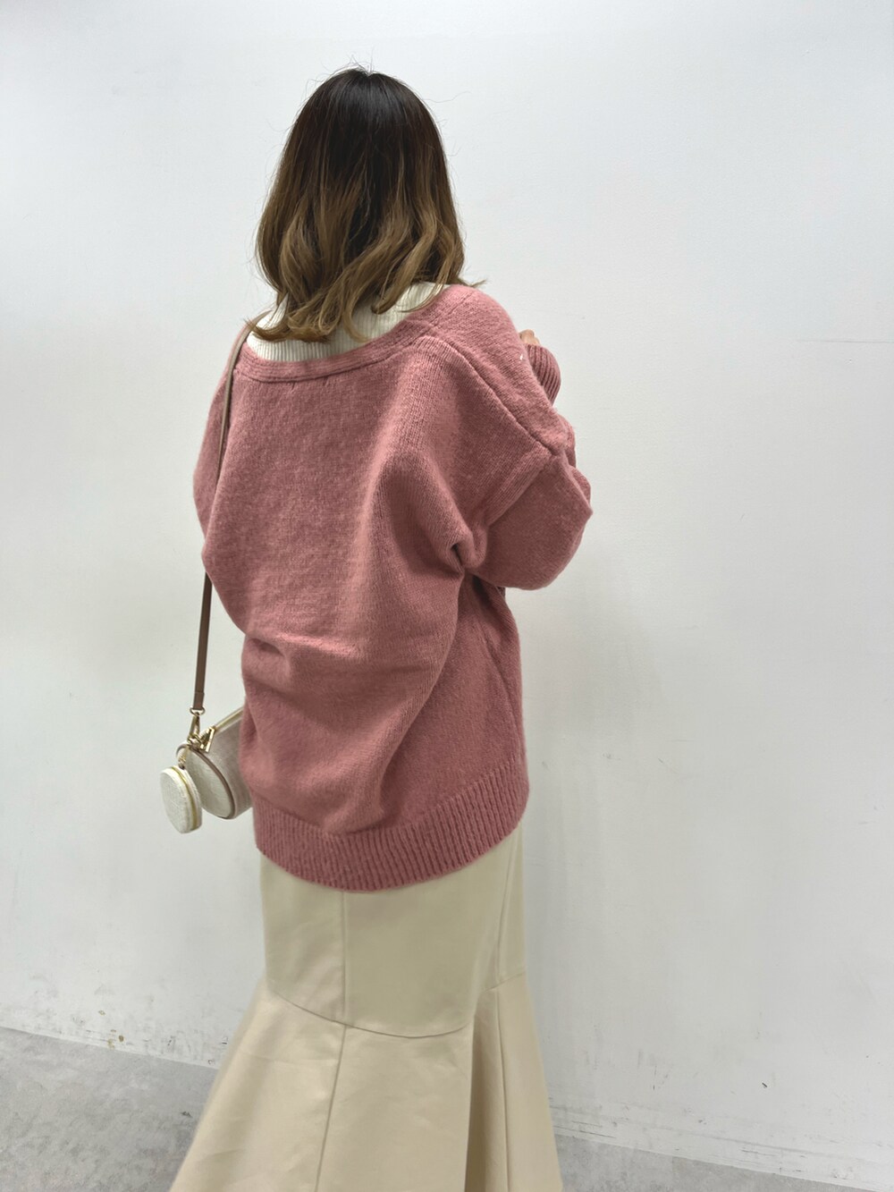 ピンク系のカーディガン/ボレロ、ホワイト系のニット/セーター、ホワイト系のスカートを着用したレディースの秋コーディネートの3枚目の写真