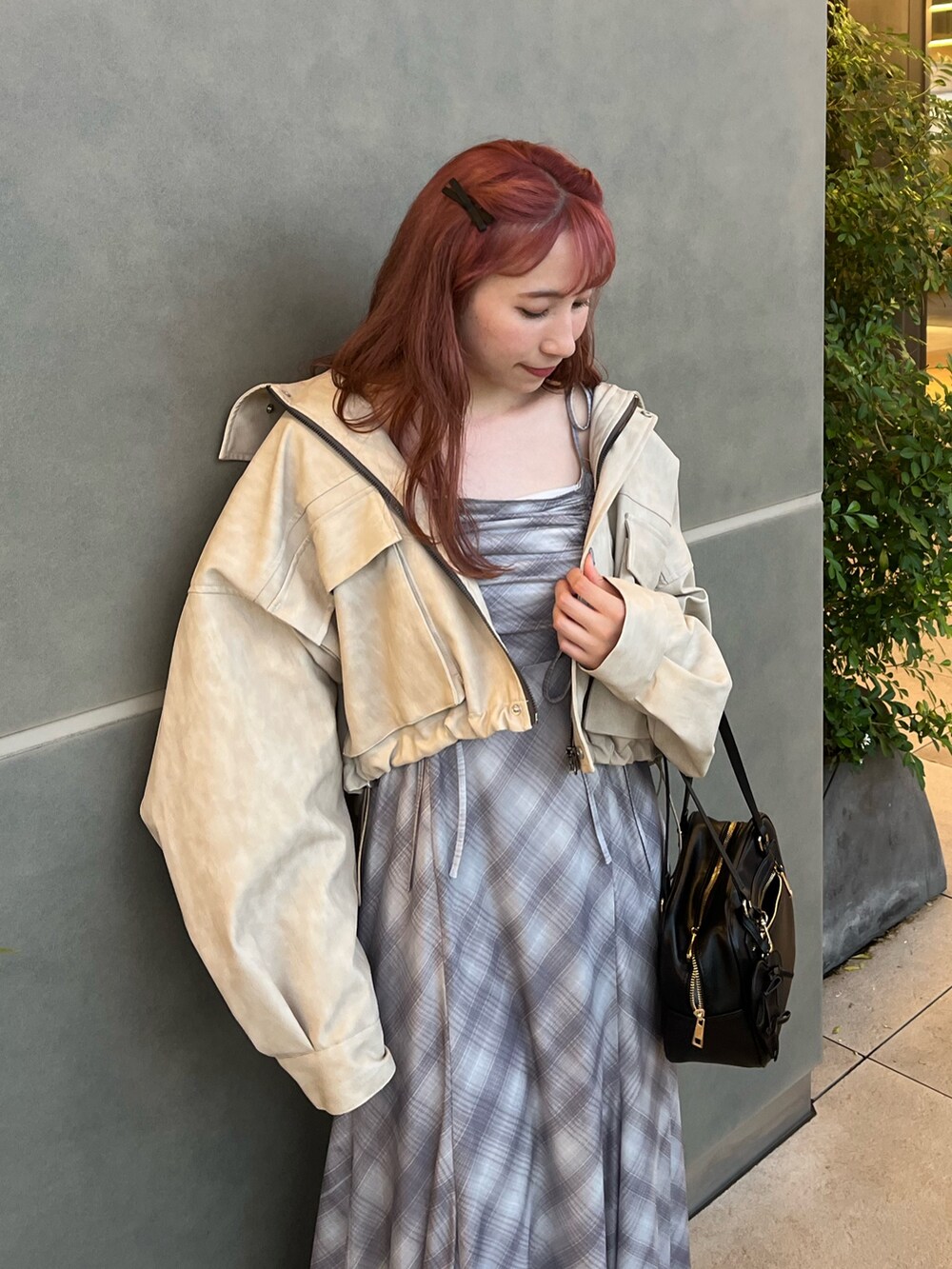 ホワイト系のブルゾン、ブラウン系のワンピース、ホワイト系のスニーカーを着用したレディースの秋コーディネートの2枚目の写真