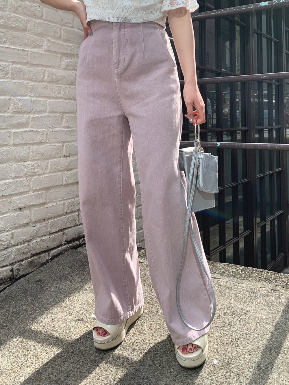 ホワイト系のシャツ/ブラウス、パープル系のデニムパンツ、シルバー系のショルダーバッグを着用したレディースの春コーディネートの4枚目の写真