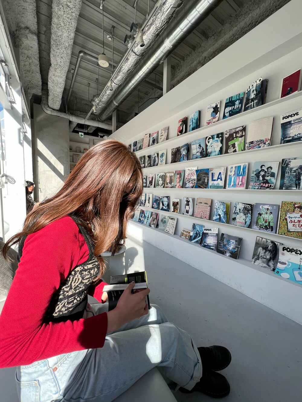 ブルー系のデニムパンツ、ブラック系のトップスを着用したレディースの冬コーディネートの2枚目の写真