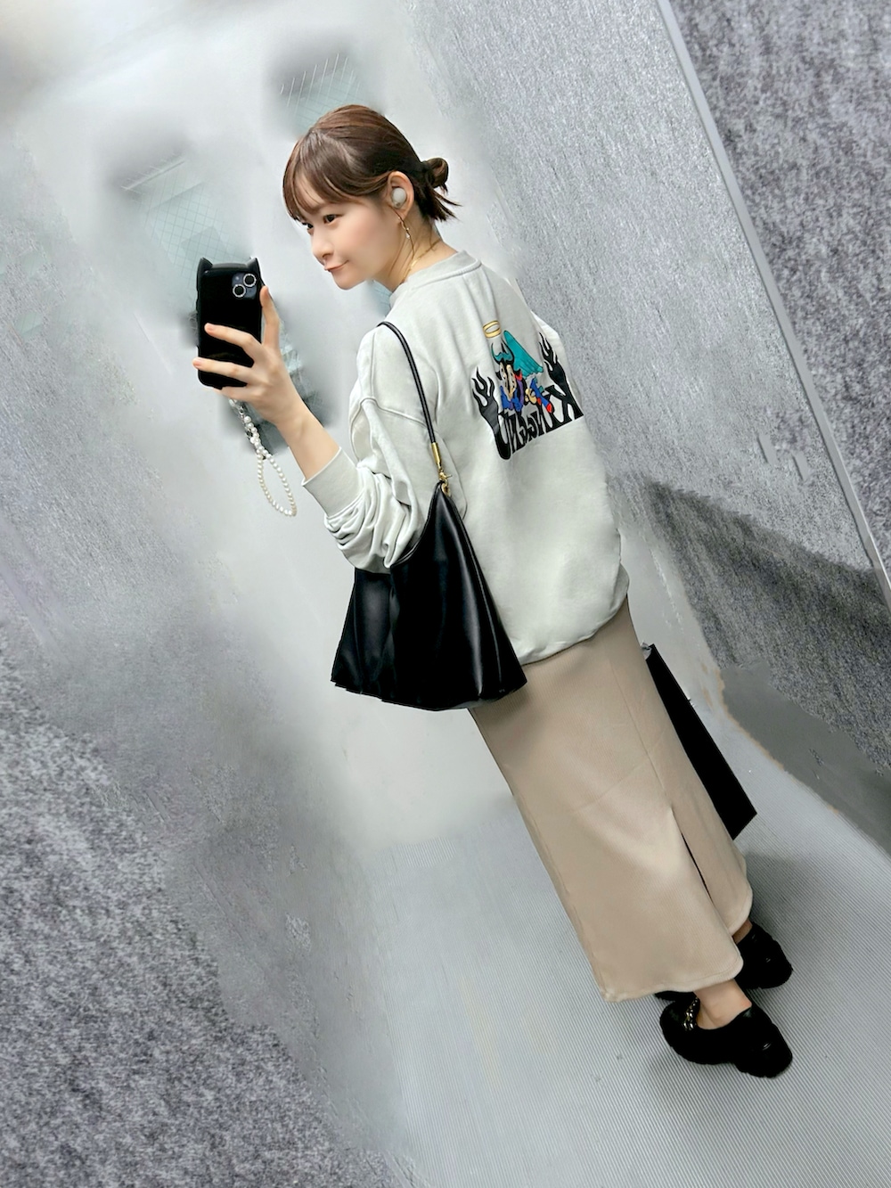 グリーン系のスウェット、ベージュ系のワンピース、ブラック系のローファーを着用したレディースの秋コーディネートの3枚目の写真