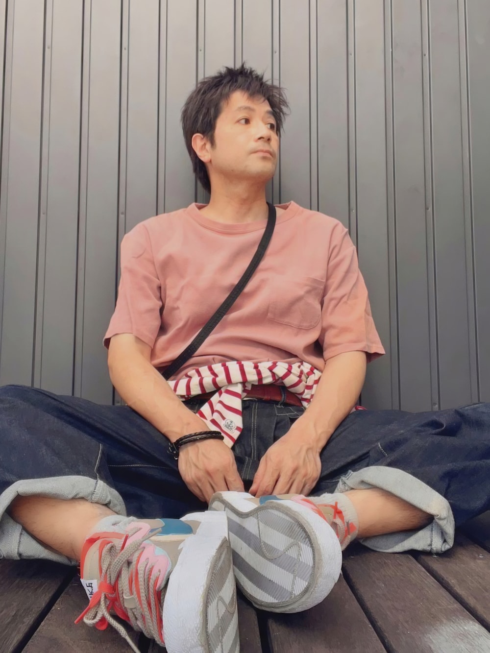 ピンク系のTシャツ/カットソー、ブラック系のショルダーバッグ、レッド系のTシャツ/カットソーを着用したメンズの春コーディネートの2枚目の写真