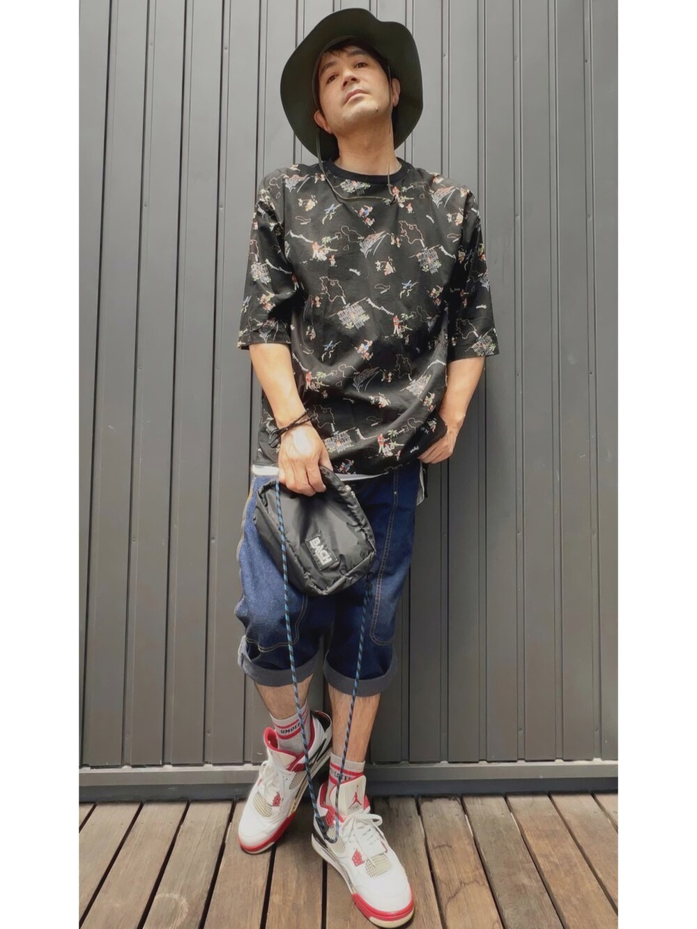 ブラック系のTシャツ/カットソー、ブラック系のタンクトップ、ブルー系のデニムパンツを着用したメンズの春コーディネートの4枚目の写真