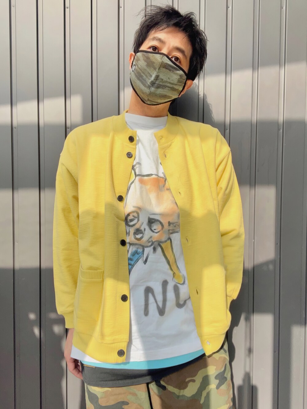 イエロー系のカーディガン/ボレロ、ホワイト系のTシャツ/カットソー、ブラック系のタンクトップを着用したメンズの春コーディネートの2枚目の写真