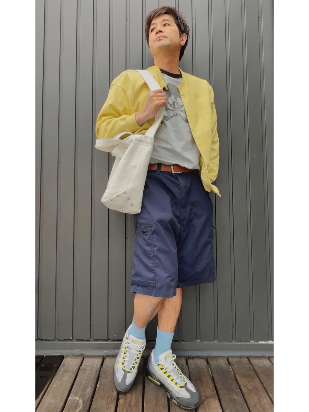 イエロー系のカーディガン/ボレロ、グレー系のTシャツ/カットソー、ブルー系のパンツを着用したメンズの春コーディネートの5枚目の写真