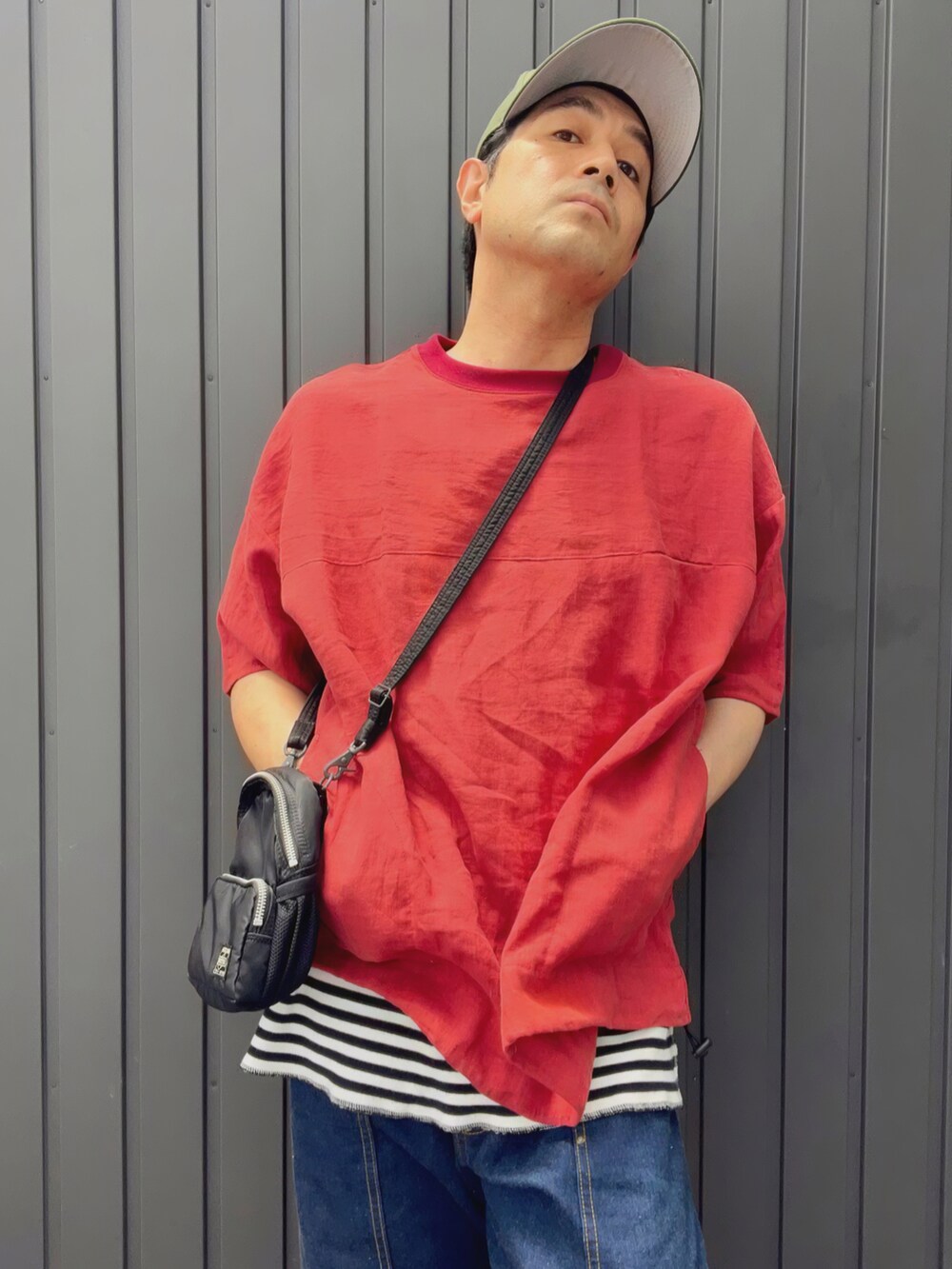 レッド系のTシャツ/カットソー、ブラック系のショルダーバッグ、その他のタンクトップを着用したメンズの夏コーディネートの2枚目の写真