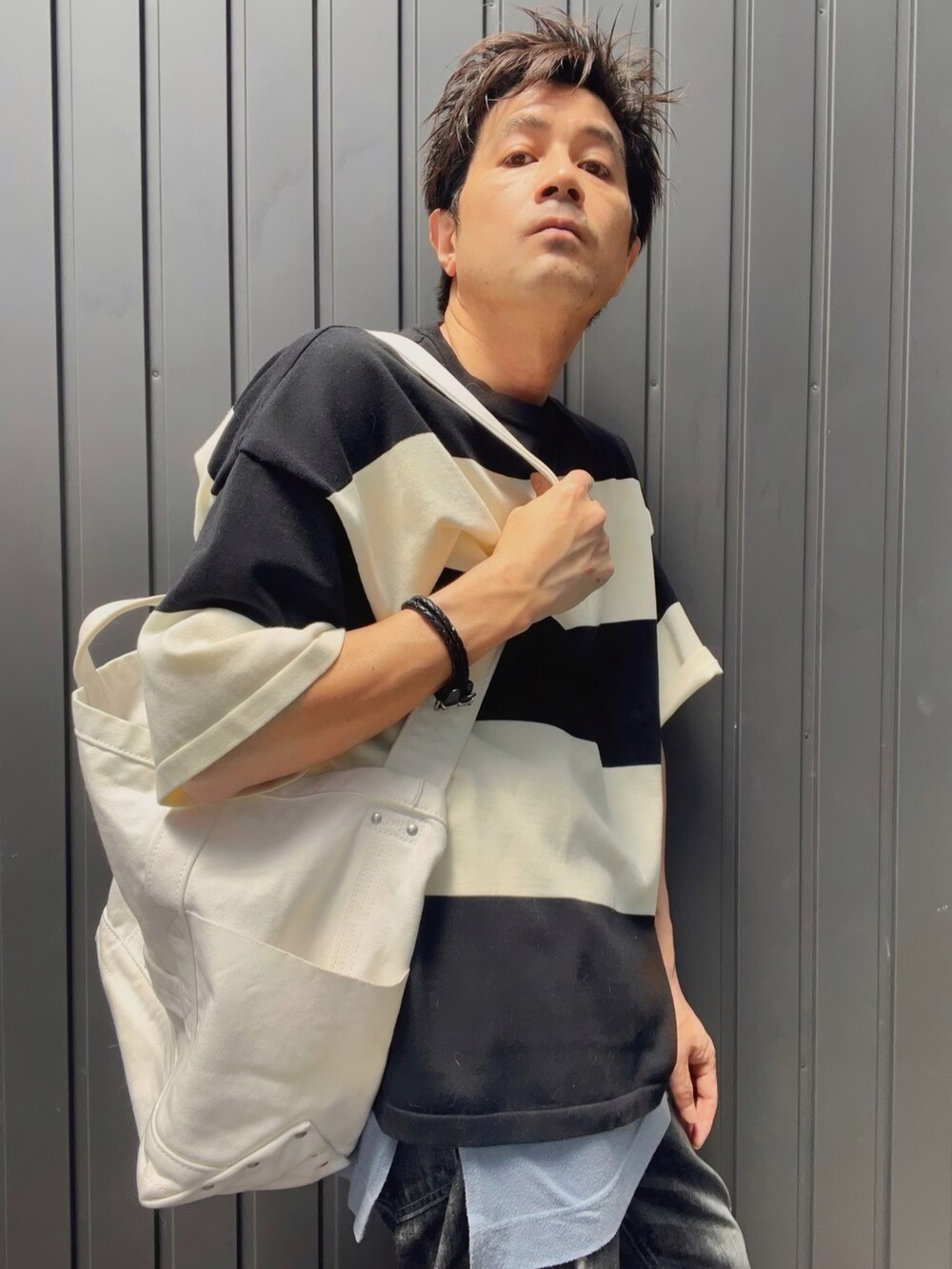 ブラック系のTシャツ/カットソー、ブルー系のタンクトップ、ホワイト系のトートバッグを着用したメンズの夏コーディネートの2枚目の写真