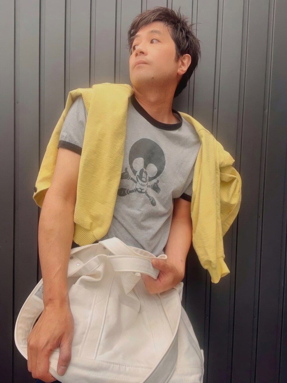 イエロー系のカーディガン/ボレロ、グレー系のTシャツ/カットソー、ブルー系のパンツを着用したメンズの春コーディネートの4枚目の写真