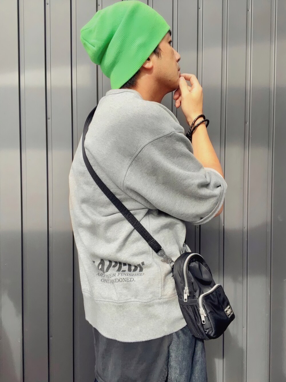 グレー系のスウェット、ブラック系のショルダーバッグ、ブラック系のタンクトップを着用したメンズの秋コーディネートの3枚目の写真