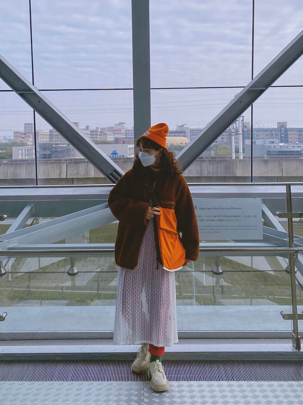 ホワイト系のシューズ、オレンジ系のショルダーバッグ、ピンク系のチノパンツを着用したレディースの春コーディネートの2枚目の写真