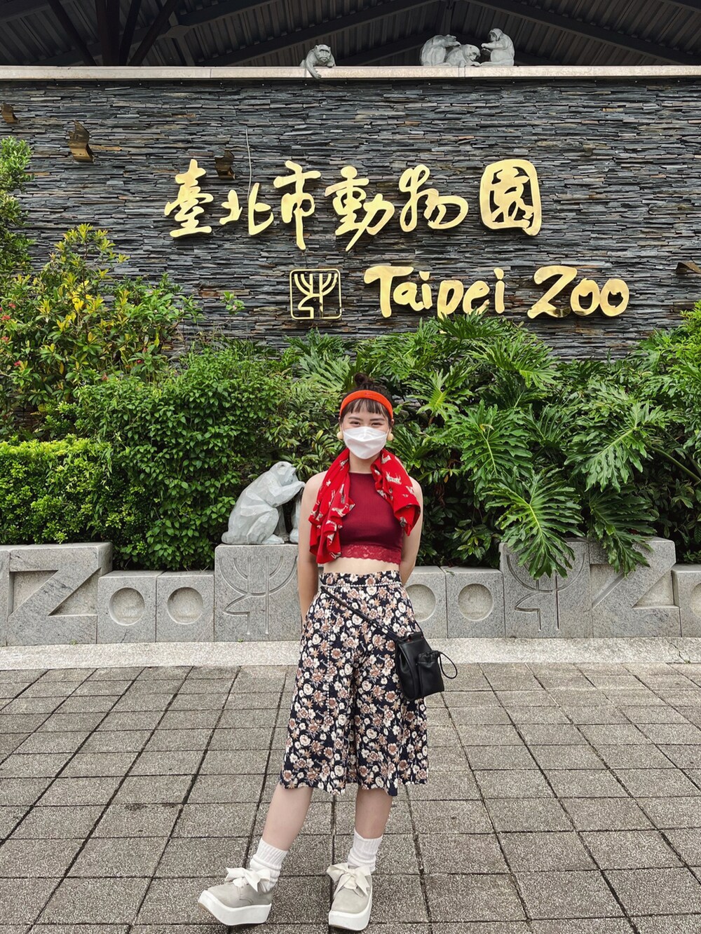 ブラック系のショルダーバッグ、グレー系のシューズ、レッド系のキャミソールを着用したレディースの夏コーディネートの2枚目の写真