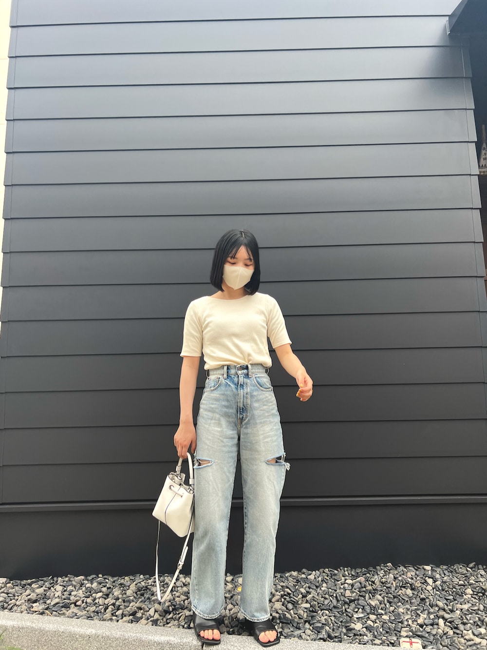 ブルー系のデニムパンツ、ホワイト系のTシャツ/カットソー、ホワイト系のバッグを着用したレディースの夏コーディネートの3枚目の写真