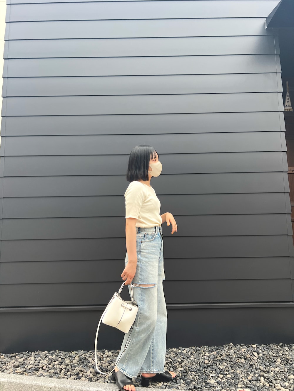 ブルー系のデニムパンツ、ホワイト系のTシャツ/カットソー、ホワイト系のバッグを着用したレディースの夏コーディネートの2枚目の写真