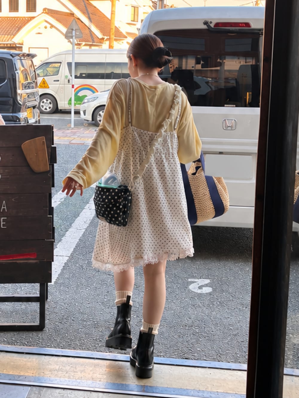 イエロー系のTシャツ/カットソー、ブラック系のショルダーバッグ、ブラック系のブーツを着用したレディースの秋コーディネートの2枚目の写真