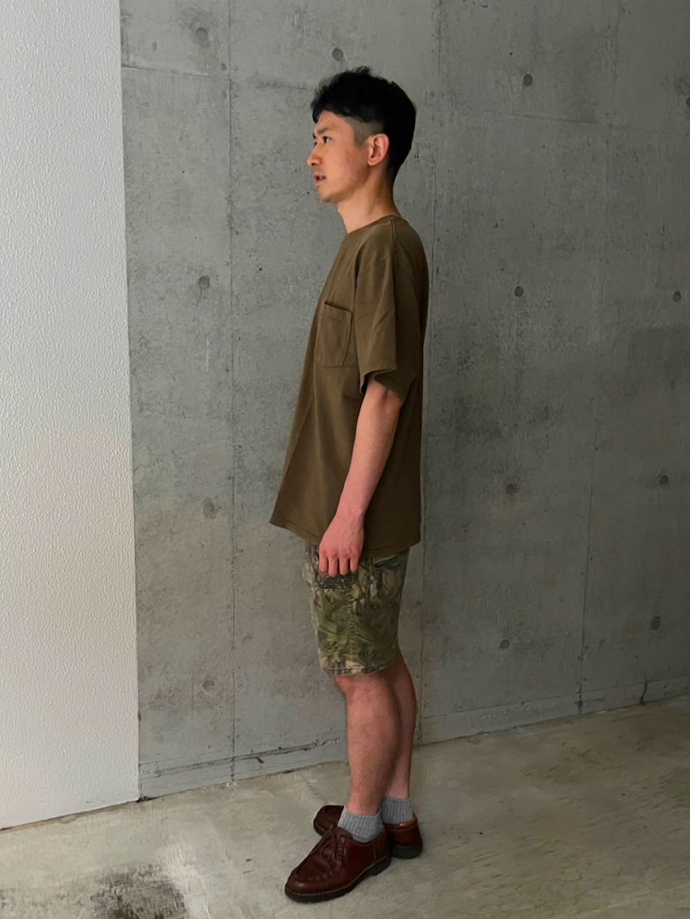 グリーン系のTシャツ/カットソー、その他のその他パンツ、ブラウン系のモカシン/デッキシューズを着用したメンズの夏コーディネートの2枚目の写真
