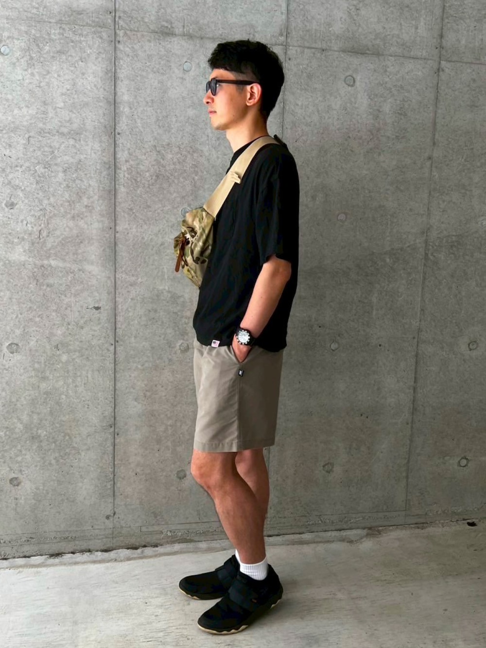 ブラック系のTシャツ/カットソー、グレー系のその他パンツ、その他のボディバッグ/ウエストポーチを着用したメンズの夏コーディネートの2枚目の写真