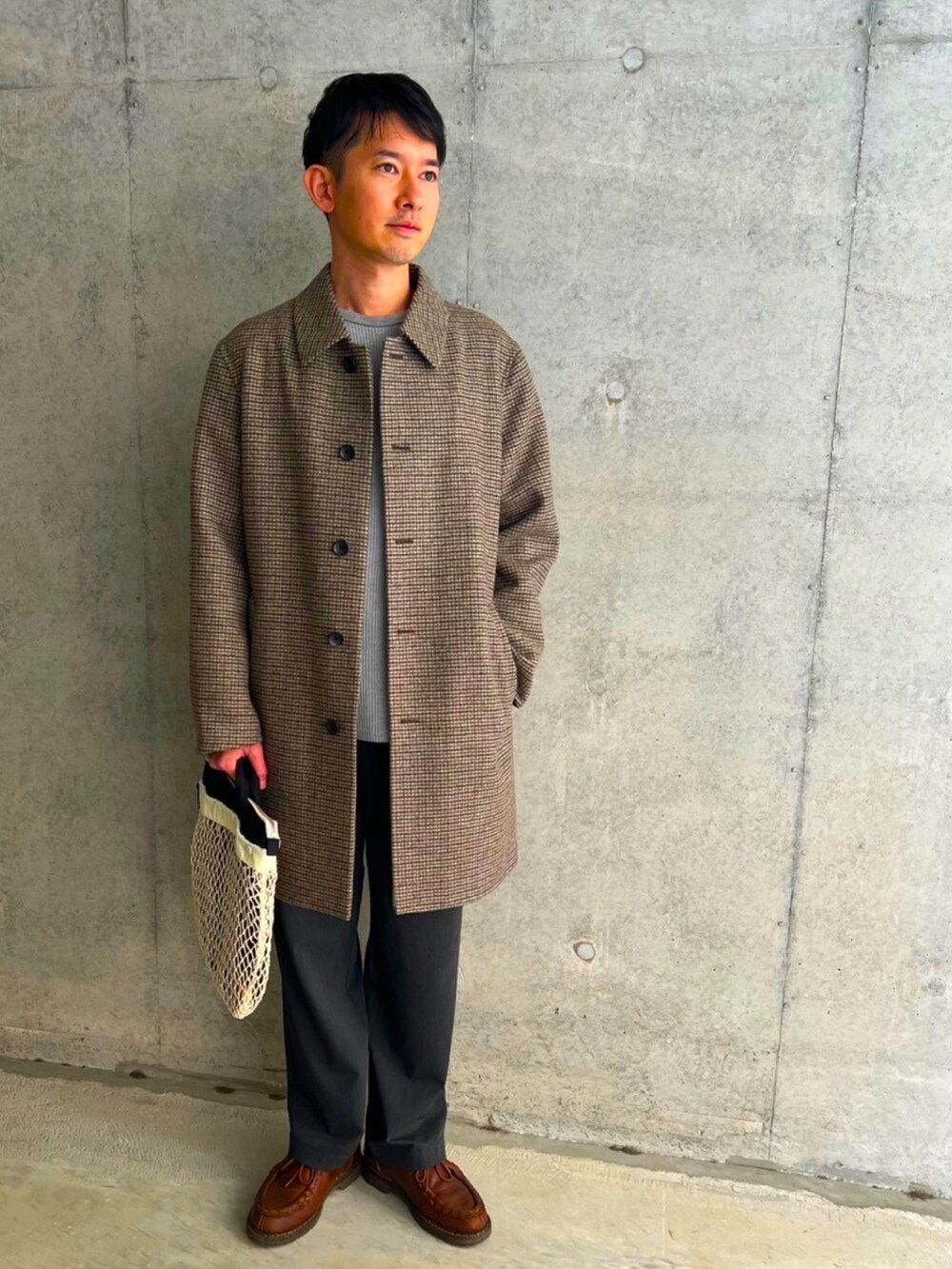 ベージュ系のステンカラーコート、グレー系のスラックス、ブラウン系のモカシン/デッキシューズを着用したメンズの冬コーディネートの3枚目の写真