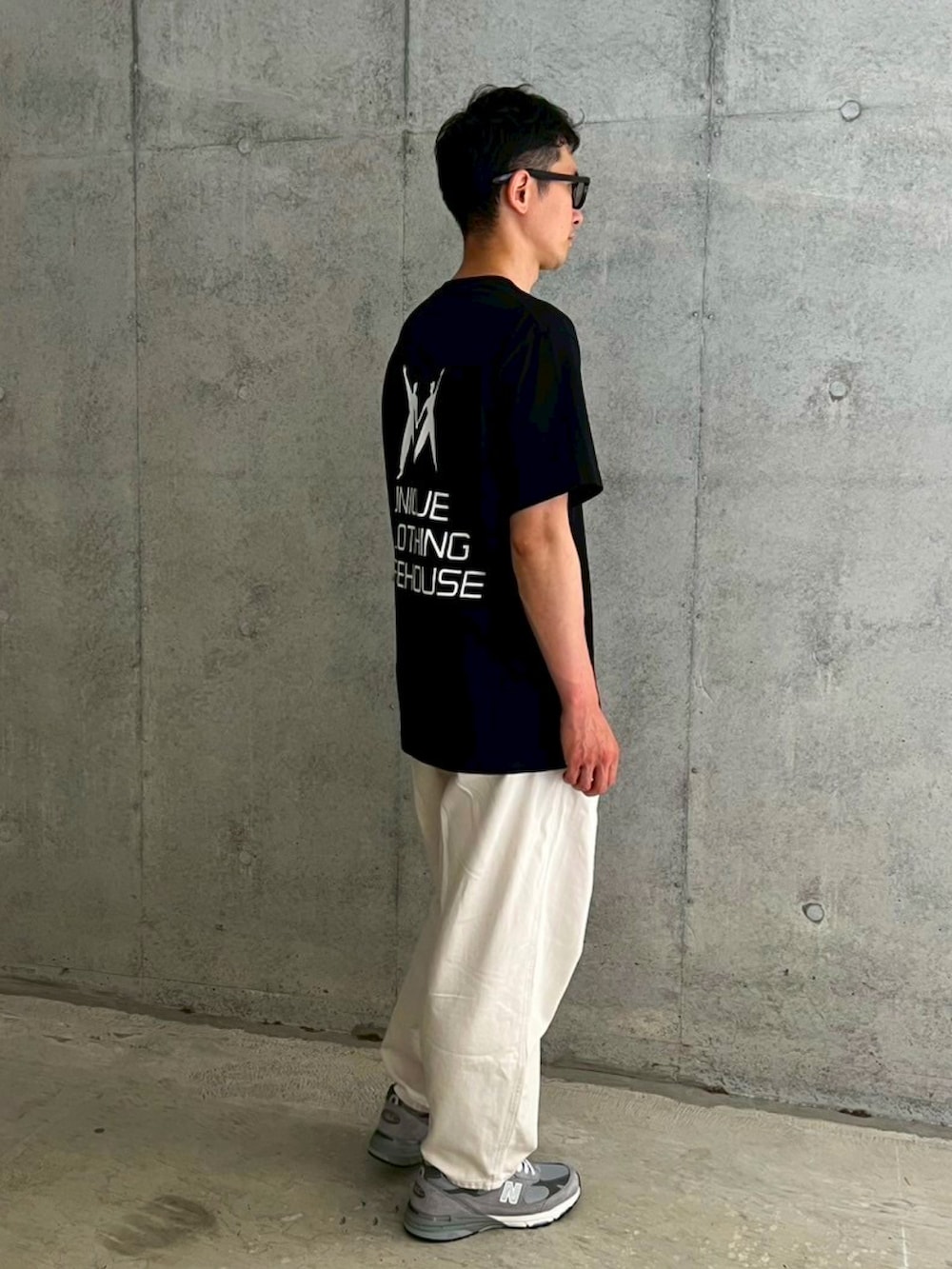 ブラック系のTシャツ/カットソー、ホワイト系のデニムパンツ、グレー系のスニーカーを着用したメンズの夏コーディネートの2枚目の写真