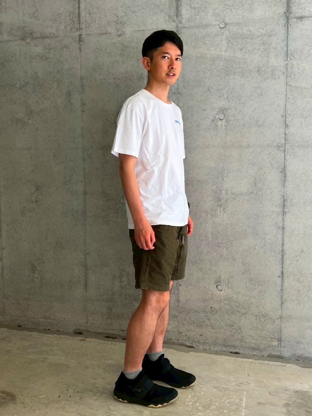 ホワイト系のTシャツ/カットソー、グリーン系のその他パンツ、ブラック系のレインシューズを着用したメンズの夏コーディネートの2枚目の写真