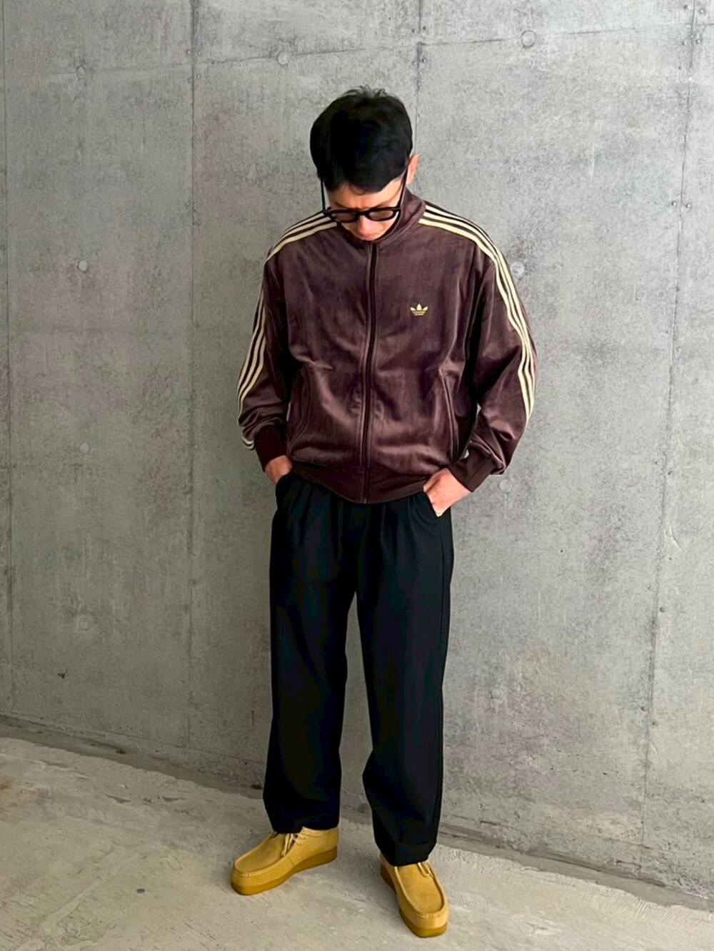 ベージュ系のモカシン/デッキシューズ、ブラウン系のジャージ、ブラック系のスラックスを着用したメンズの秋コーディネートの2枚目の写真