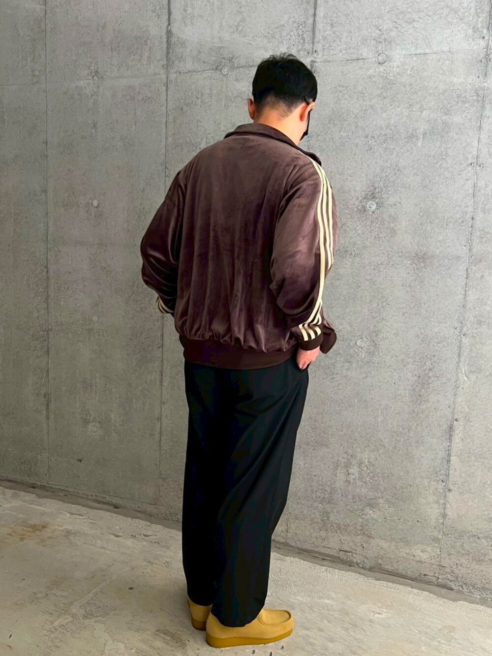 ベージュ系のモカシン/デッキシューズ、ブラウン系のジャージ、ブラック系のスラックスを着用したメンズの秋コーディネートの3枚目の写真