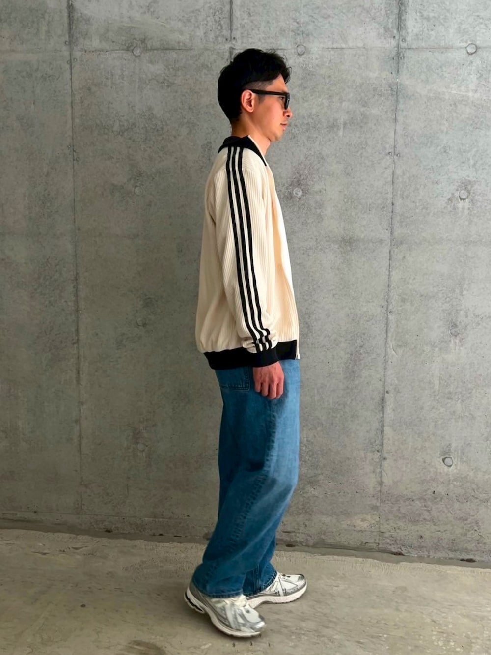 ホワイト系のジャージ、ホワイト系のTシャツ/カットソー、ブルー系のデニムパンツを着用したメンズの春コーディネートの2枚目の写真