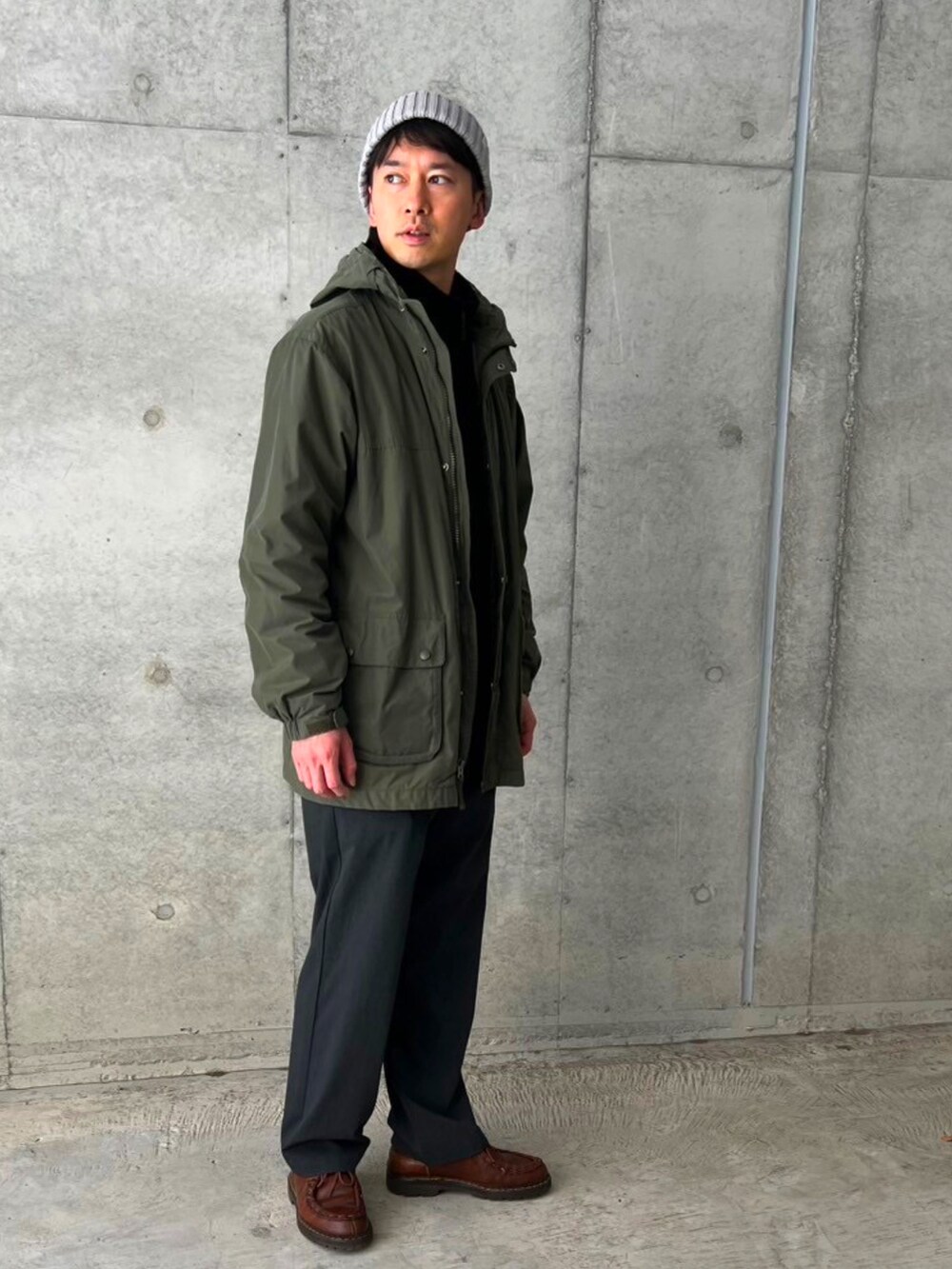 グリーン系のジャケット/アウター、ブラック系のブルゾン、グレー系のスラックスを着用したメンズの冬コーディネートの2枚目の写真