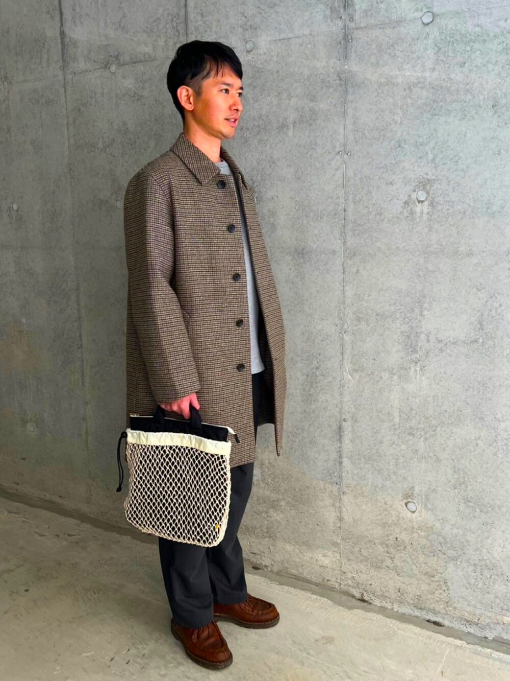 ベージュ系のステンカラーコート、グレー系のスラックス、ブラウン系のモカシン/デッキシューズを着用したメンズの冬コーディネートの2枚目の写真