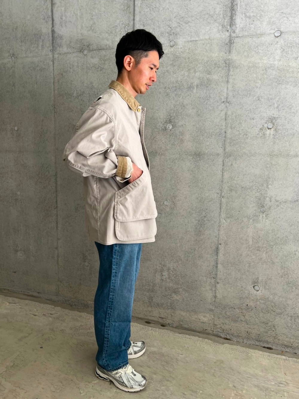 ホワイト系のカバーオール、ブルー系のデニムパンツ、シルバー系のスニーカーを着用したメンズの春コーディネートの2枚目の写真