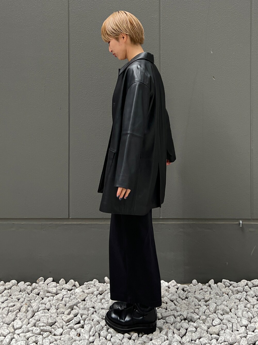 ブラック系のライダースジャケット、グリーン系のTシャツ/カットソー、ブラック系のブーツを着用したレディースの秋コーディネートの3枚目の写真