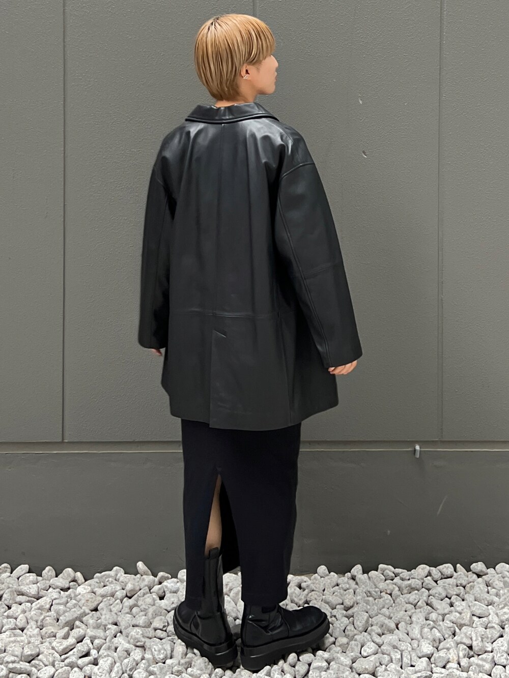 ブラック系のライダースジャケット、グリーン系のTシャツ/カットソー、ブラック系のブーツを着用したレディースの秋コーディネートの4枚目の写真