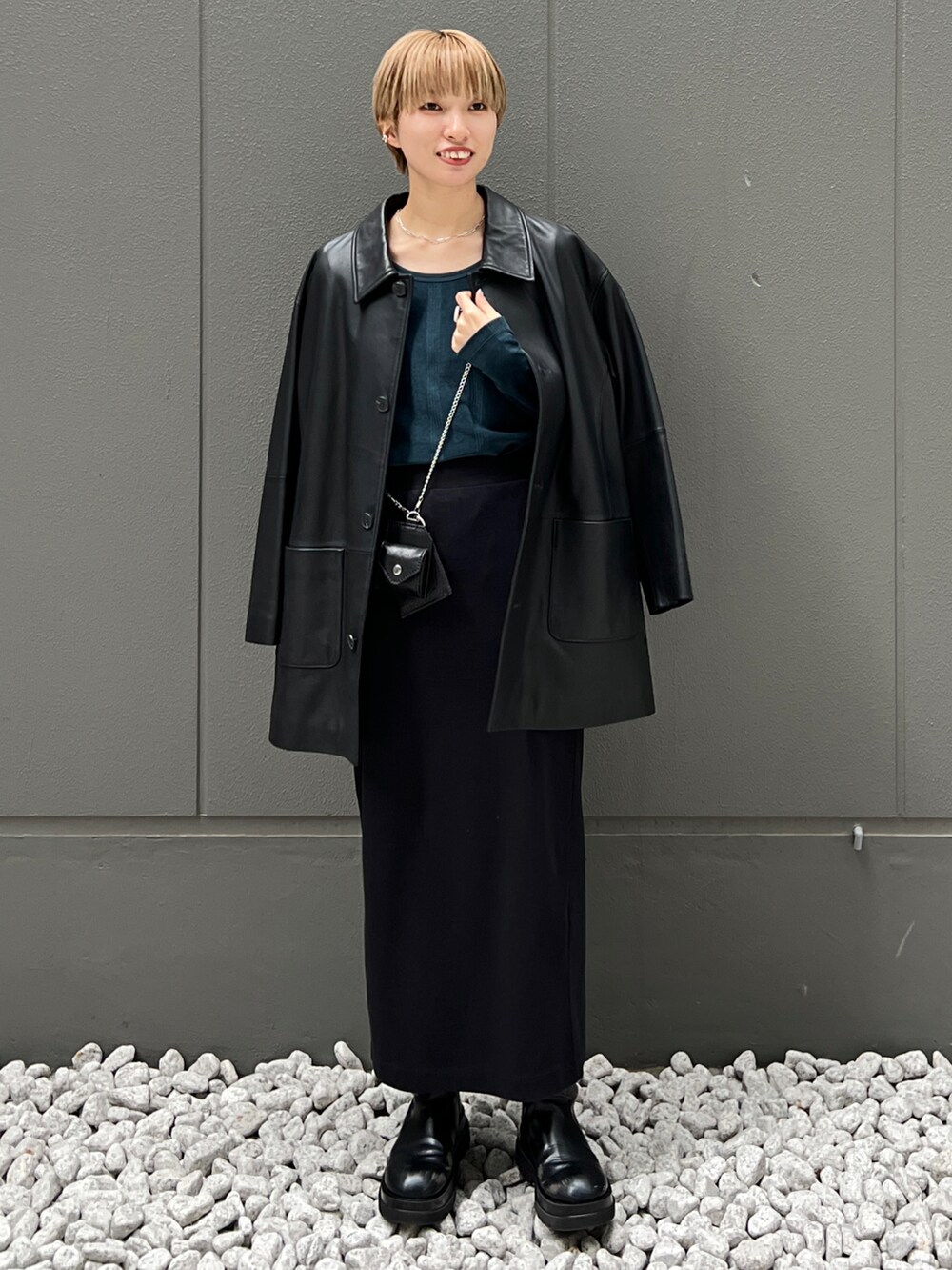 ブラック系のライダースジャケット、グリーン系のTシャツ/カットソー、ブラック系のブーツを着用したレディースの秋コーディネートの2枚目の写真