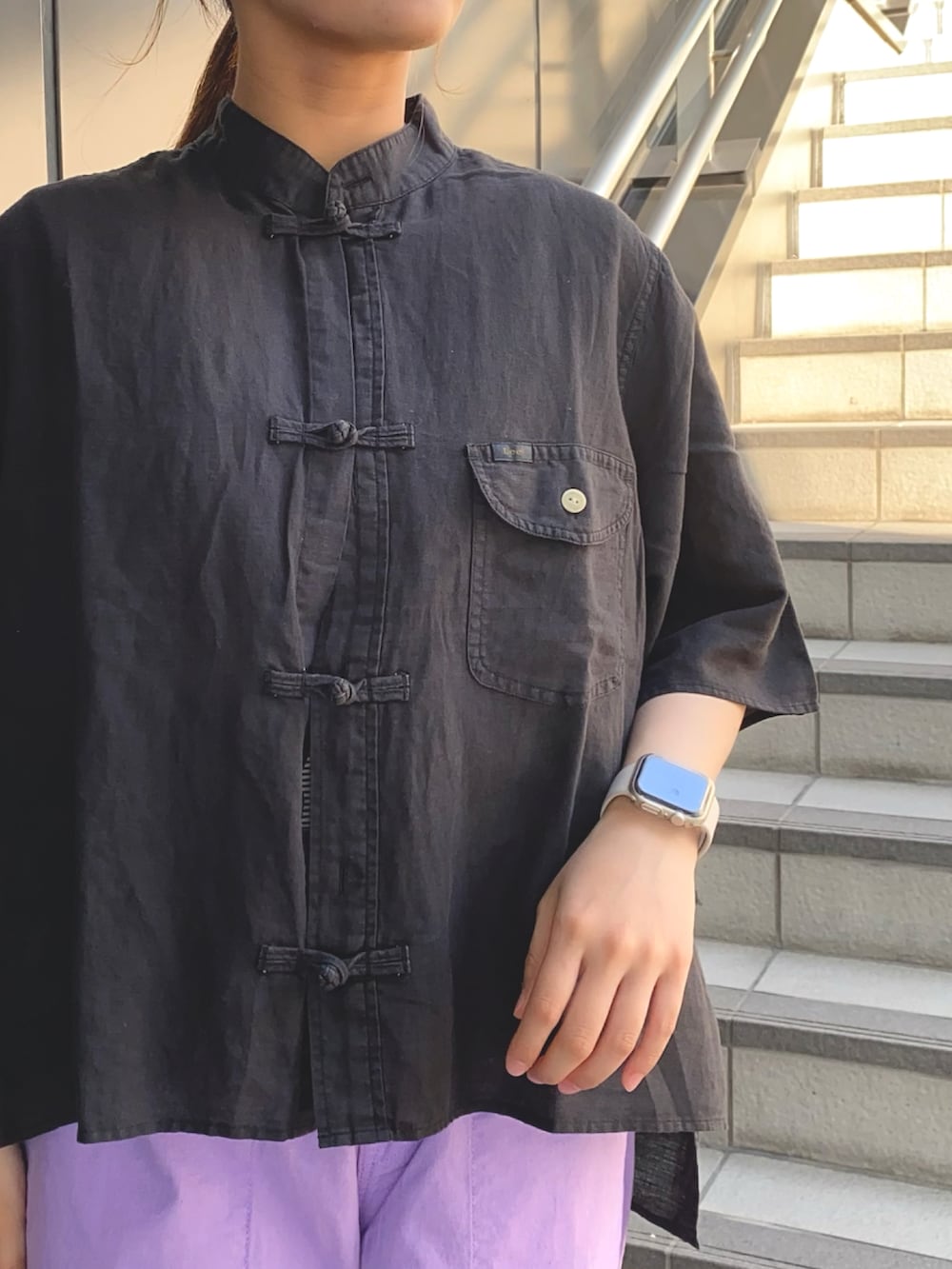 ブラック系のシャツ/ブラウス、ブラック系のTシャツ/カットソー、パープル系のデニムパンツを着用したレディースの夏コーディネートの4枚目の写真