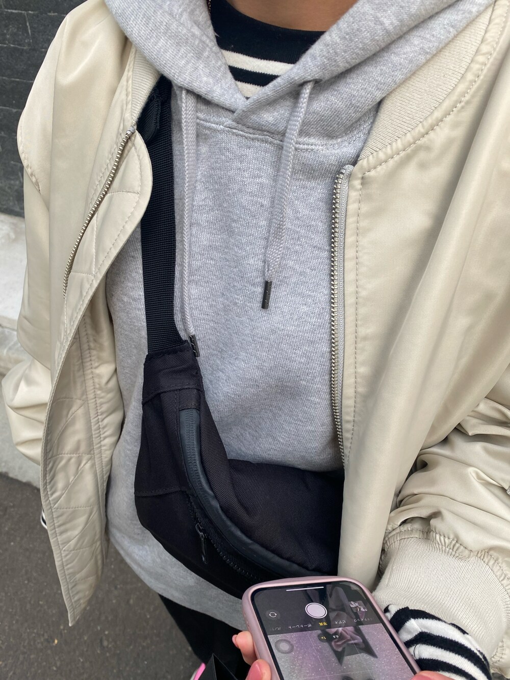 ホワイト系のMA-1、ピンク系のスニーカーを着用したレディースの春コーディネートの2枚目の写真